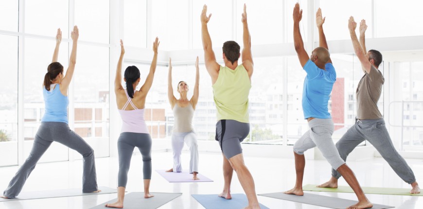 A young instructor leading her class in some stretching exercises